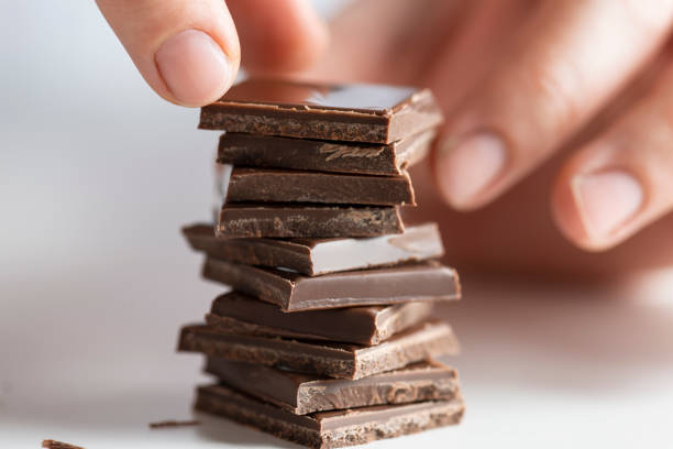 Woman With Chocolate Woman is stacking the chocolate chips. chocolate fingers stock pictures, royalty-free photos & images