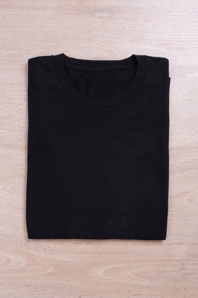istock Foled black t-shirt on wooden background 1168554254
