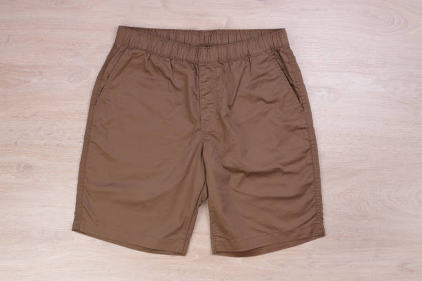 istock Brown casual short pants on wooden background 1168554263