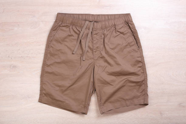 istock Brown casual short pants on wooden background 1168554294