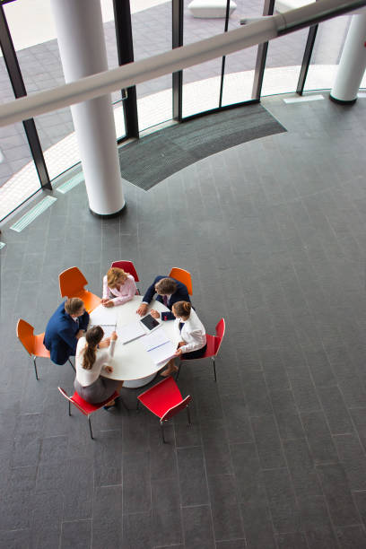 istock High angle view of colleagues planning while sitting during meeting at office 1168556068