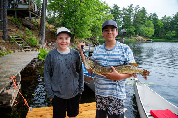 istock Two brothers proudly holding a fish they have caught. 1168556159