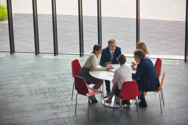 istock High angle view of colleagues planning while sitting during meeting at office 1168556381
