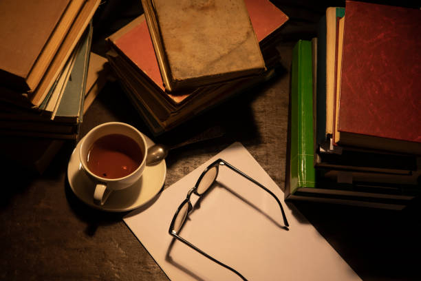 istock Piles of books and a white cup with tea. 1168557400