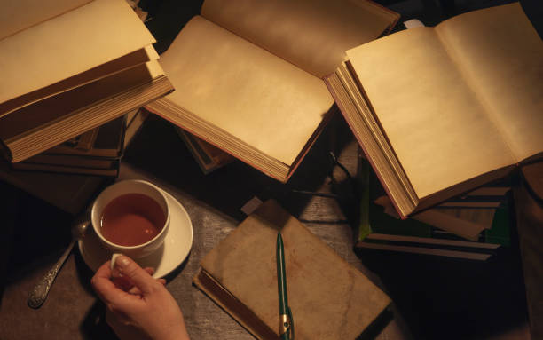 istock Piles of books and a white cup with tea. 1168557427