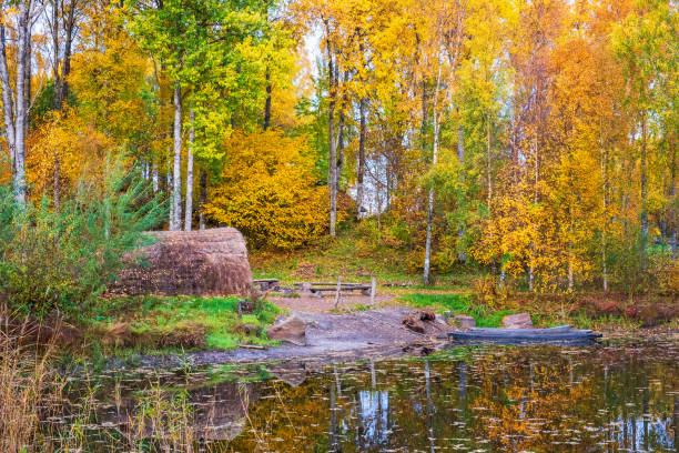 huttes au bord du lac avec des canots de pirogues une belle journée d'automne - logboat photos et images de collection