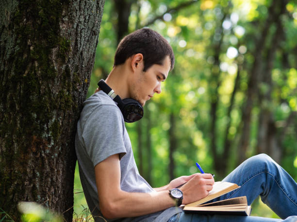 istock Guy student with a book or textbook in the Park. Close up 1168570729