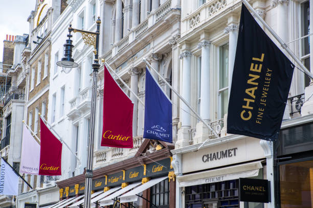 London, UK - August 13, 2019: Old Bond street view with flags of famous fashion houses. London, UK - August 13, 2019: Old Bond street view with flags of famous fashion houses. Bond Street is a major shopping street in the West End of London for luxury designer brands high street shops stock pictures, royalty-free photos & images