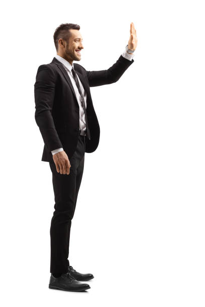 istock Young man in a suit greeting with hand and smiling 1168580555