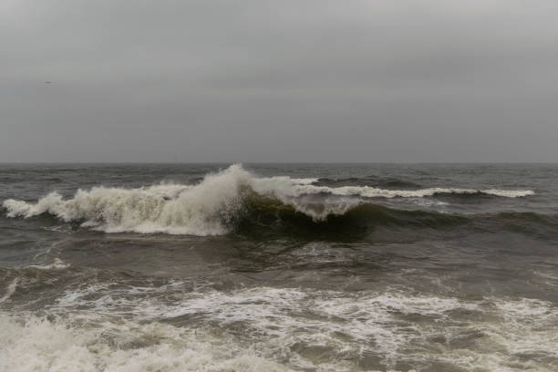 istock Angry waves in the ocean with strong currents and a moody sky. Beach and sea safety warning background. Angry moody peaceful danger concept. 1168580607