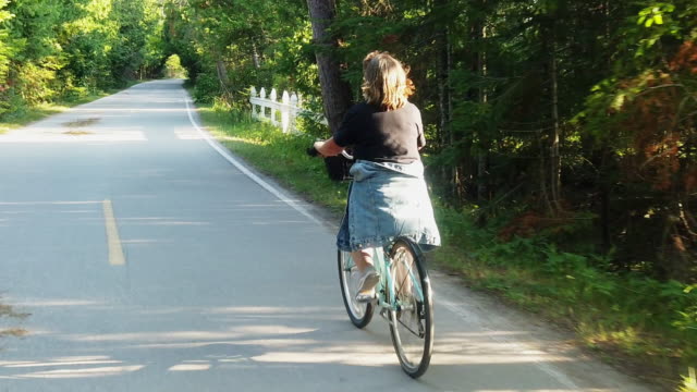 A Video Clip Of A Mature Smiling Woman Riding A Bicycle Enjoying The Scenery