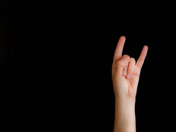 istock Hand with horns sign on black background with copy space 1168585618