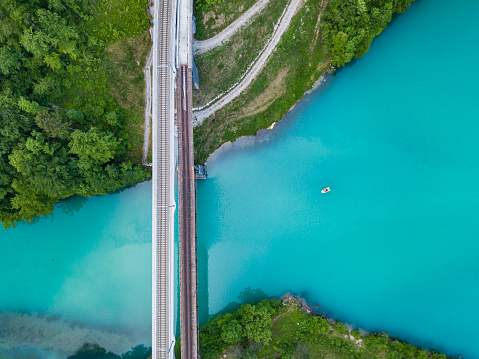 Railway bridge crossing the dammed Steyr river, Austria. The Steyr is a river in the alps of Upper Austria, rising in the Totes Gebirge. There is a huge dam and reservoir near the village of Klaus and the small lake of the dammed river is usually in a deep turquoise color.