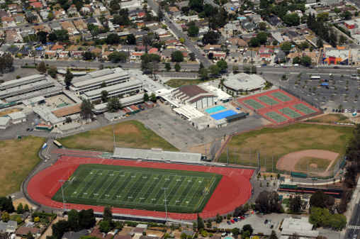 Large urban high school campus with athletic facilities including all-weather track, football field, basketball courts, swimming pools, baseball diamond, and tennis courts. James Lick High School (public), San Jose, California.