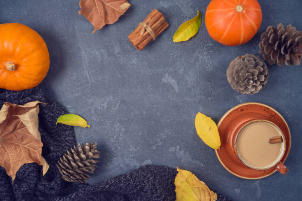 istock Autumn concept with coffee cup, pumpkin and fall leaves over blackboard background. Top view from above 1168587598