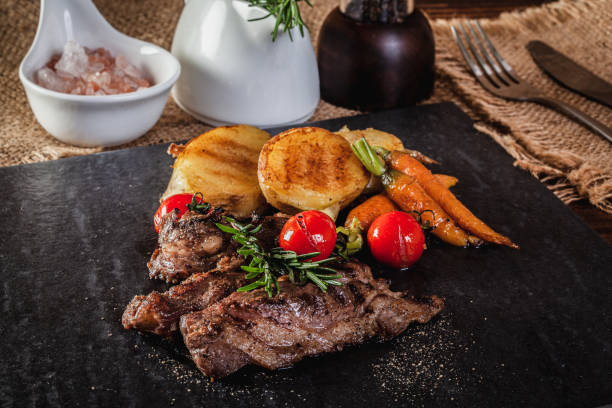 istock Beef steak with vegetables and spices on a cutting board 1168587714
