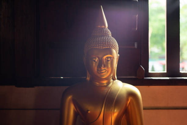 istock Golden buddha inside window with lighting on the face 1168587852