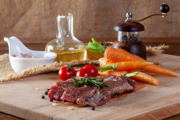 istock Beef steak with vegetables and spices on a cutting board 1168588267