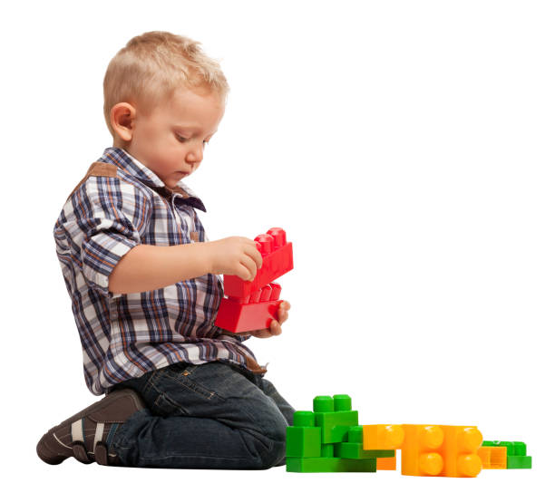 istock Boy Playing With Toy Blocks While Sitting Against White Background 1168589689