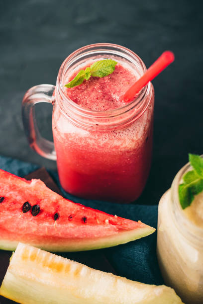 istock Smoothie from watermelon and melon in a jars with fresh mint leaves, grape on dark background 1168589982