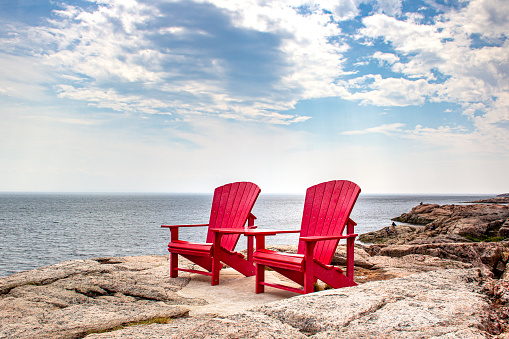 Adirondack red chairs near Tadoussac, Quebec, Canada for whales watching in the St-Lawrence river