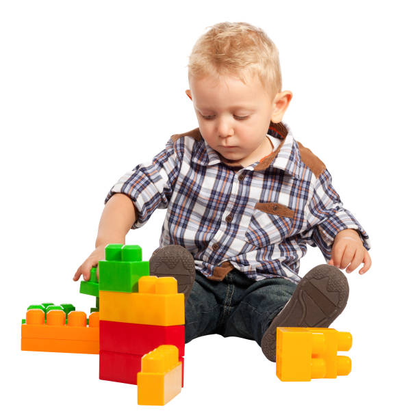 istock Boy Playing With Toy Blocks While Sitting Against White Background 1168592190