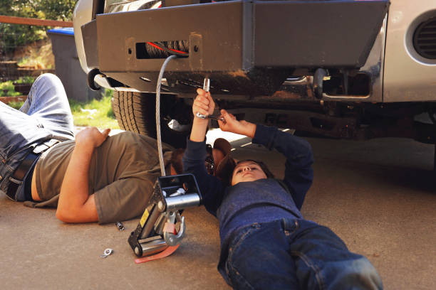 istock 8 year old boy working on truck with father 1168594437