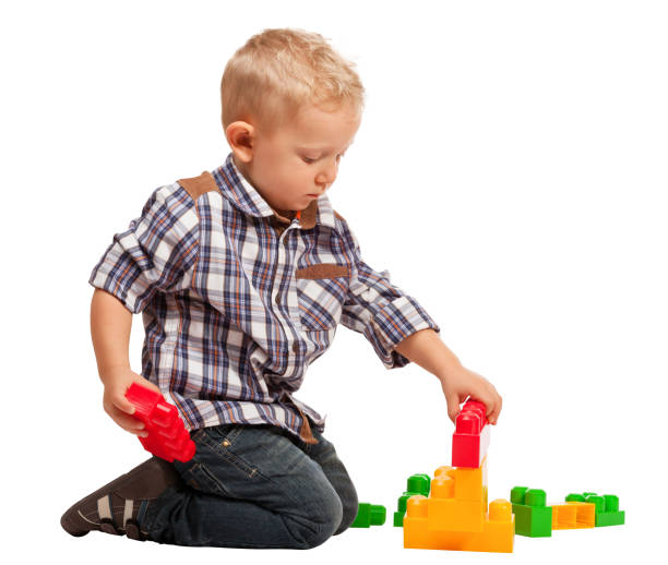 istock Boy Playing With Toy Blocks While Sitting Against White Background 1168595422