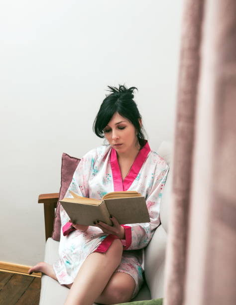 istock High Angle View Of Woman Reading Book While Sitting On Sofa At Home 1168595492