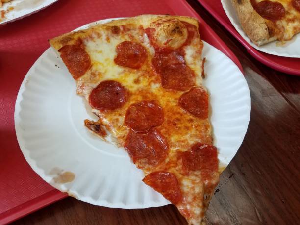 istock pepperoni pizza slice on paper plate and red tray 1168597436