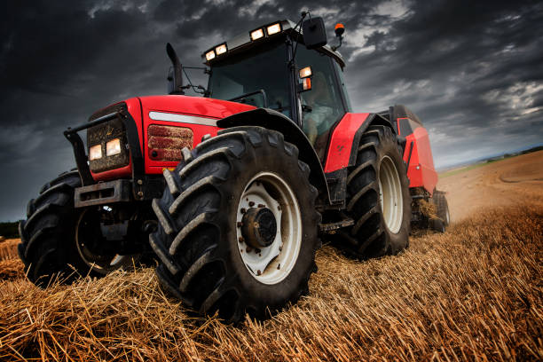 istock tractor and its trailer to press the straw 1168605331