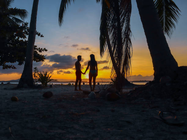 istock Couple watching sunset with palm trees in Palawan 1168605451