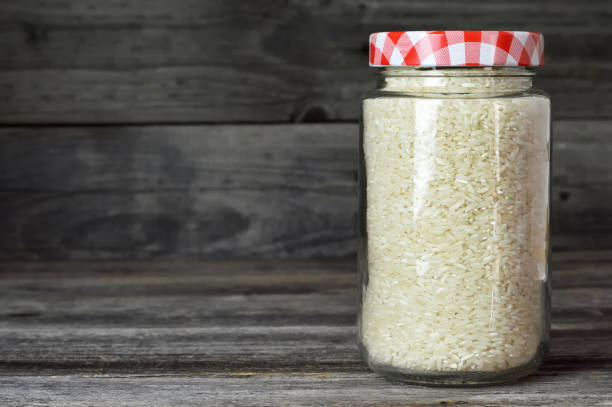 Rice in a glass jar on wooden background