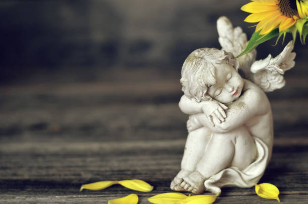 istock Little cherub on wooden background 1168606289