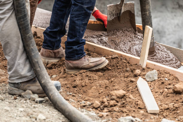 istock Construction Workers Pouring And Leveling Wet Cement Into Wood Framing 1168609198