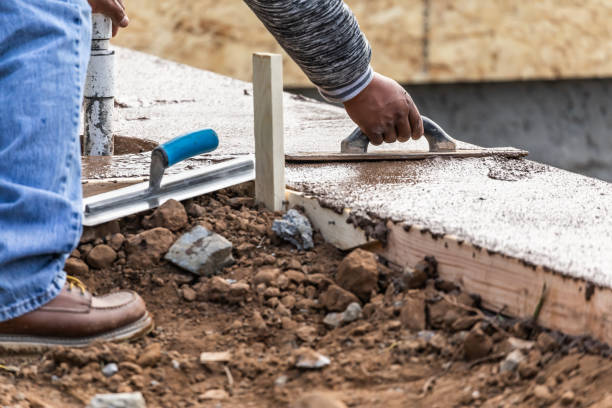 istock Construction Worker Using Wood Trowel On Wet Cement Forming Coping Around New Pool 1168609236