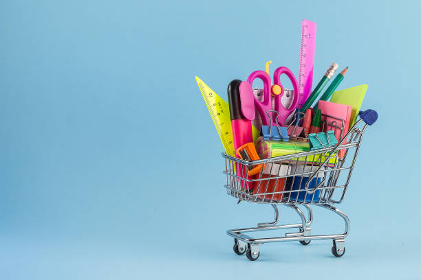 istock Shopping cart with different stationery on the light blue background 1168609383
