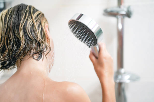 istock Girl holds hand watering a shower 1168611522