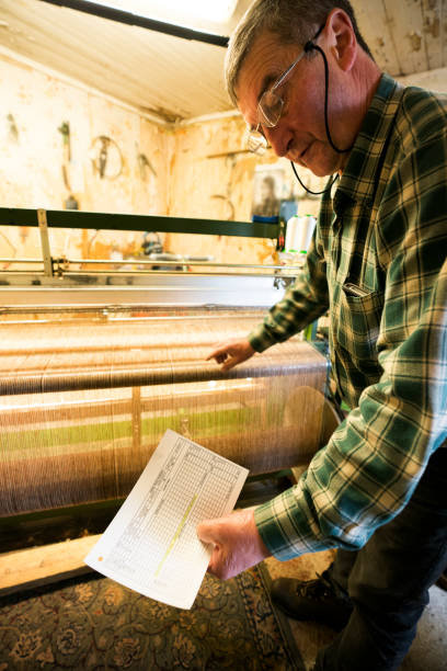 istock tweed cloth weaver looks at the pattern card 1168613170