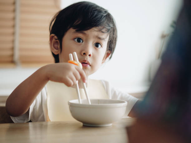 istock Smiling little boy eating on high chair 1168614490