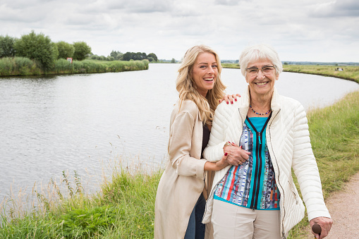 Portrait of a dutch grandmother and granddaughter in an outdoors setting. On the background river Eem (Baarn, the Netherlands)