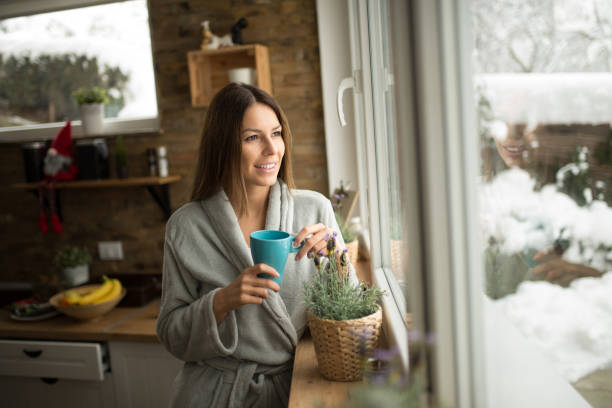 istock Cozy winter morning at home, looking through the window and drinking first coffee. 1168615853