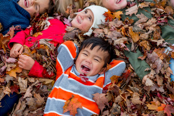 istock Diverse group of children playing in the fall leaves 1168618052