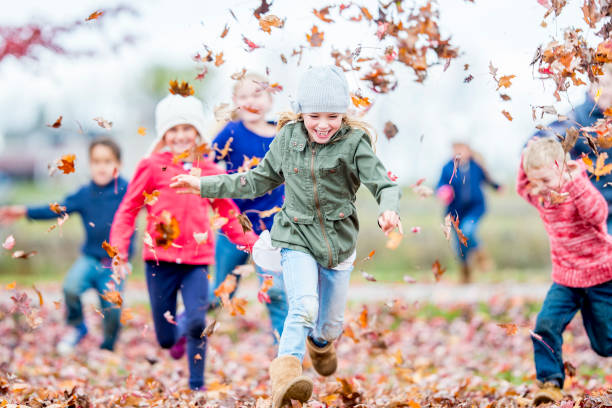 istock Diverse group of children playing in the fall leaves 1168618059