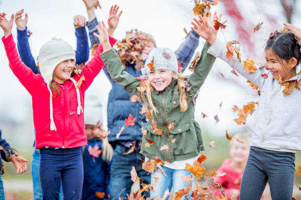 istock Diverse group of children playing in the fall leaves 1168618061