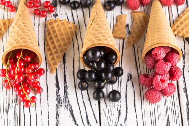 istock Summer berries in waffle cone on wooden background 1168618736