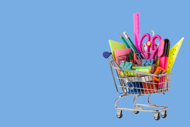 istock Shopping cart with different stationery on the light blue background 1168619954