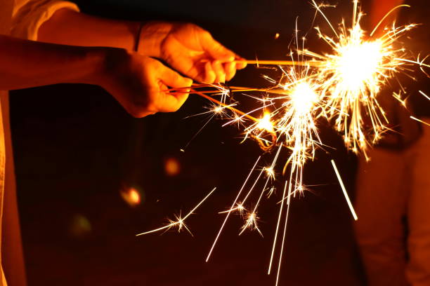 istock People enjoying hand-held fireworks on the beach 1168621073