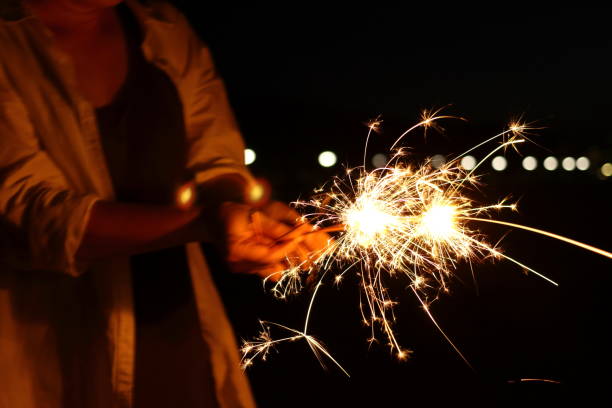 istock People enjoying hand-held fireworks on the beach 1168621097