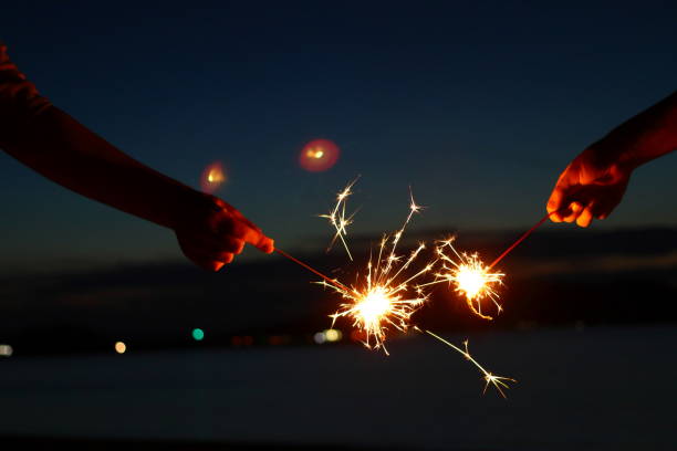 istock People enjoying hand-held fireworks on the beach 1168621189